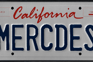 A california license plate with the word " mercedes " written in red and blue letters.